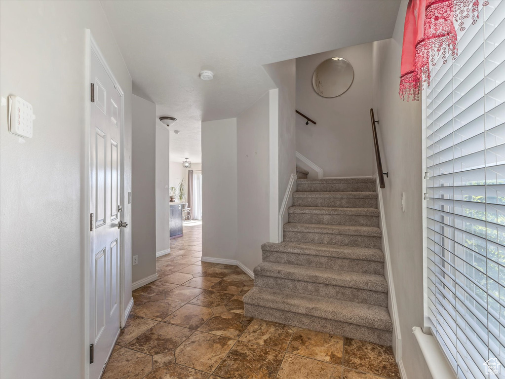 Stairway with stone finish flooring and baseboards