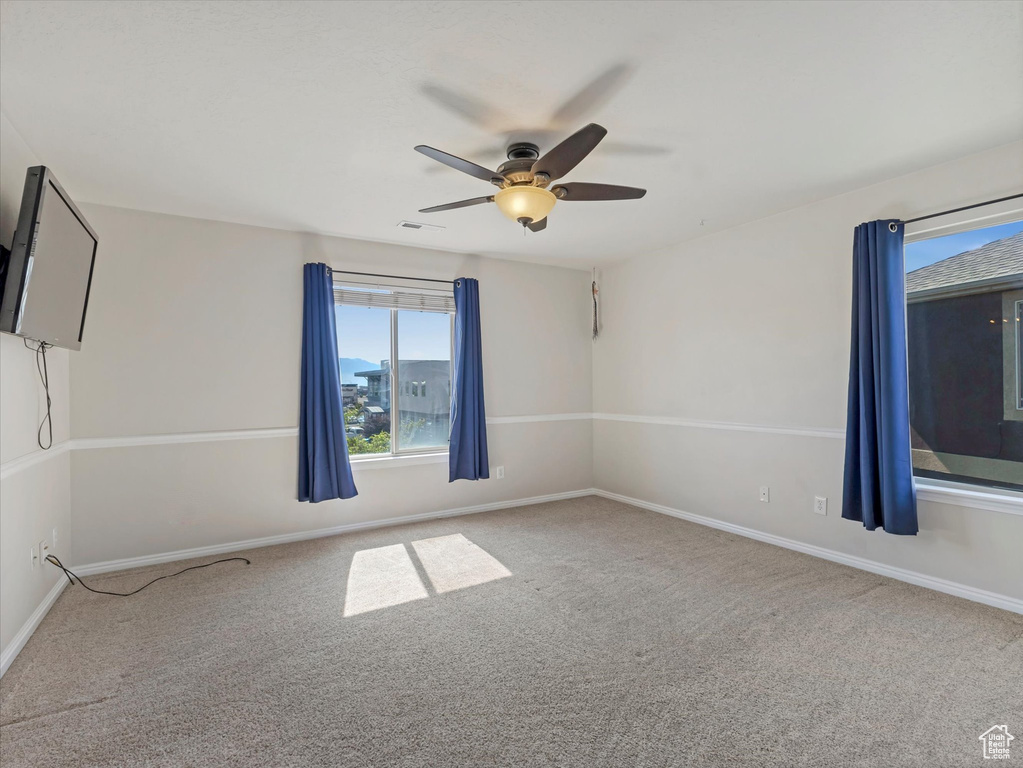 Unfurnished room with carpet, a ceiling fan, and baseboards