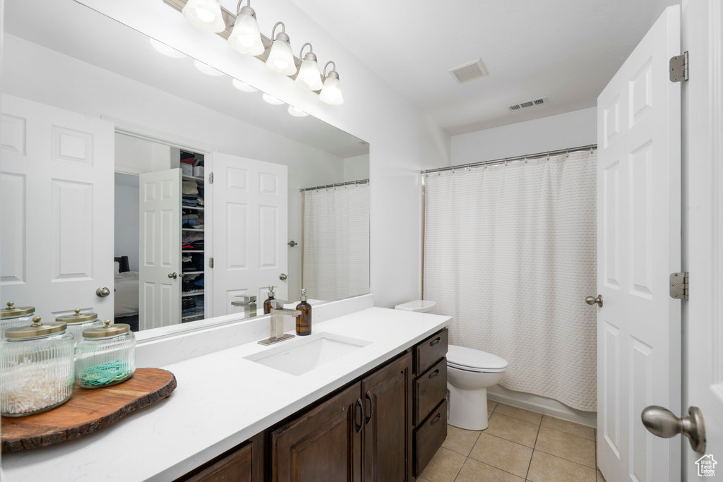 Bathroom featuring vanity, tile patterned flooring, toilet, and a shower with shower curtain