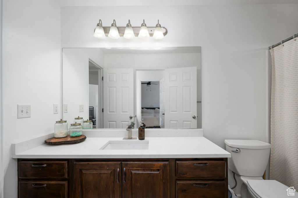 Full bathroom featuring vanity, toilet, and curtained shower