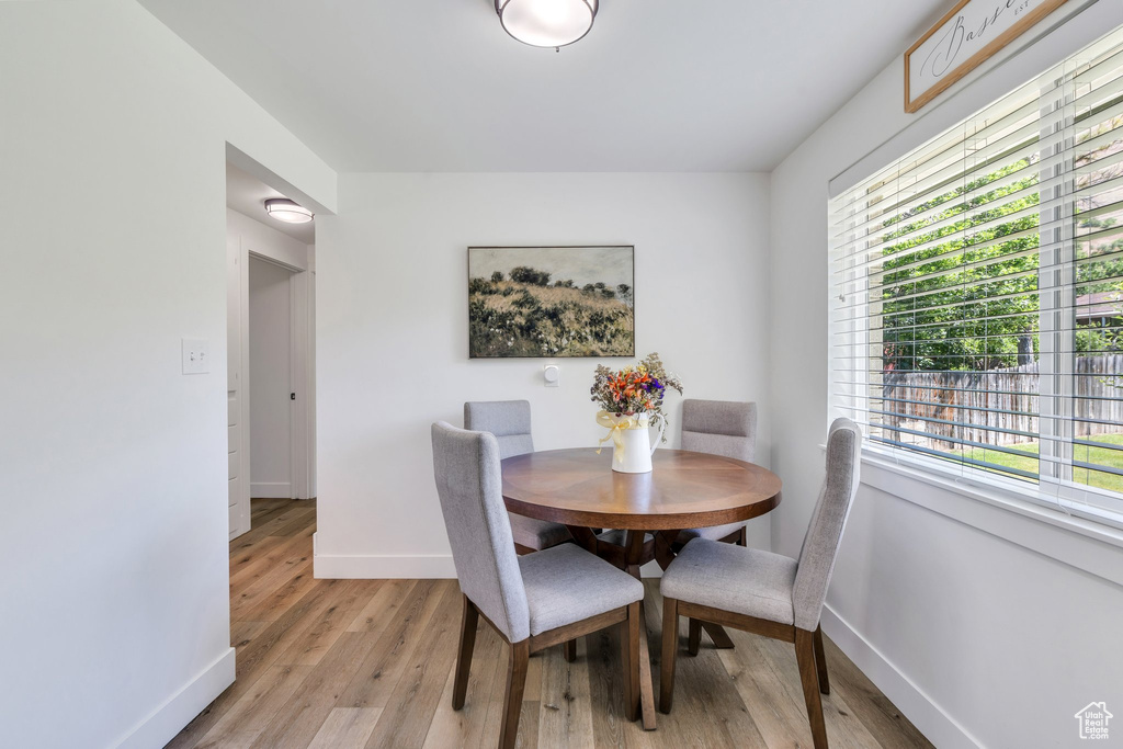 Dining space featuring baseboards, healthy amount of natural light, and light wood finished floors