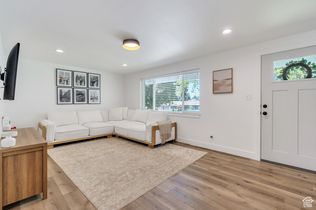 Living room with light wood-style floors, baseboards, and recessed lighting