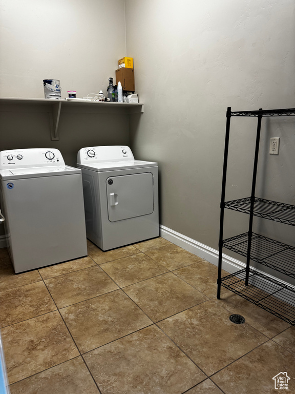 Laundry room featuring washer and dryer, baseboards, and tile patterned floors