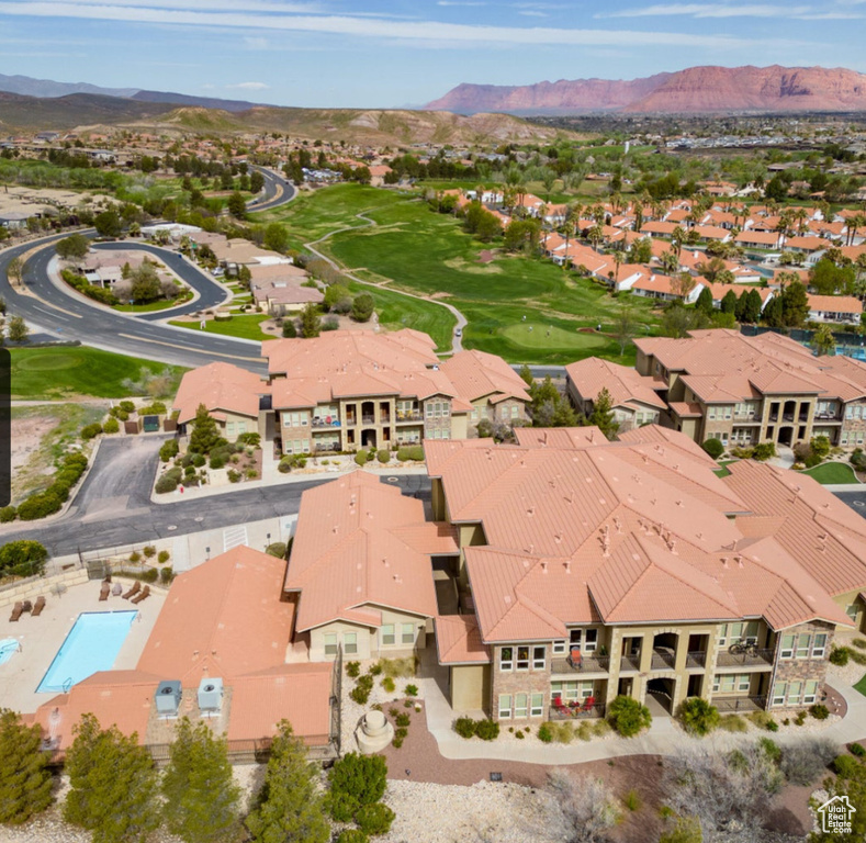 Aerial perspective of suburban area featuring a mountain backdrop and a golf club