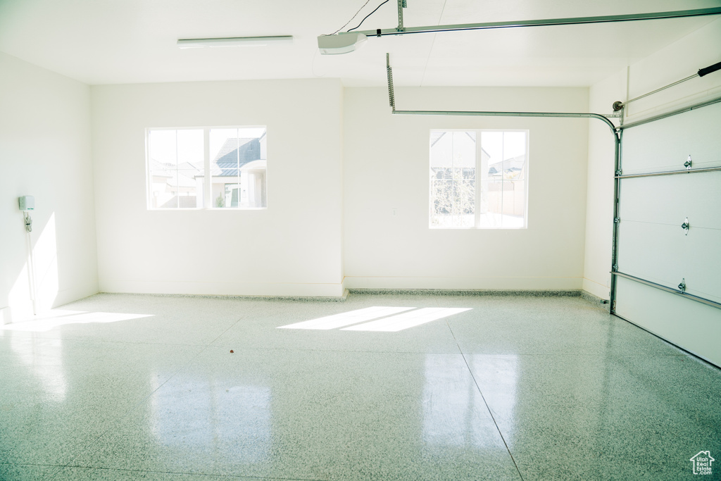 Garage with baseboards and a garage door opener