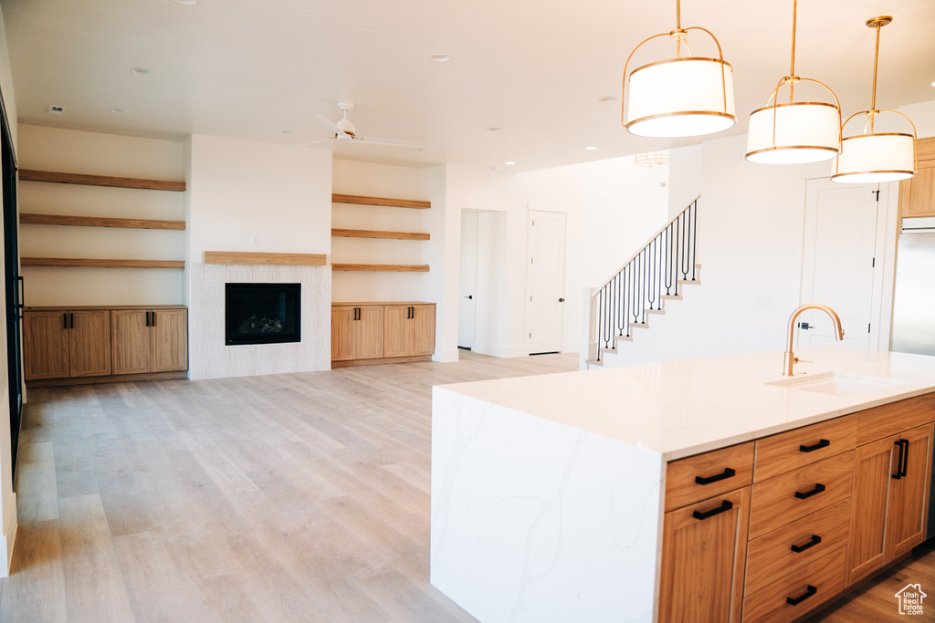Kitchen featuring a sink, light wood-style flooring, ceiling fan, open floor plan, and recessed lighting