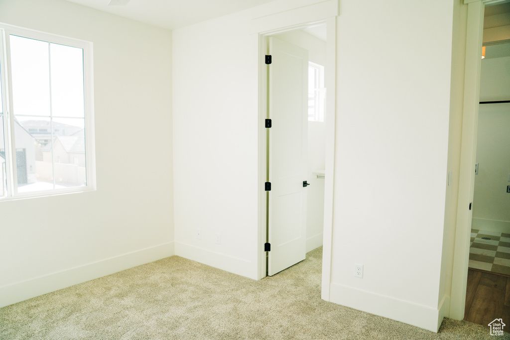 Unfurnished bedroom with carpet flooring and baseboards