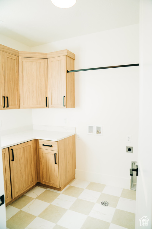 Washroom with light floors, cabinet space, electric dryer hookup, washer hookup, and baseboards