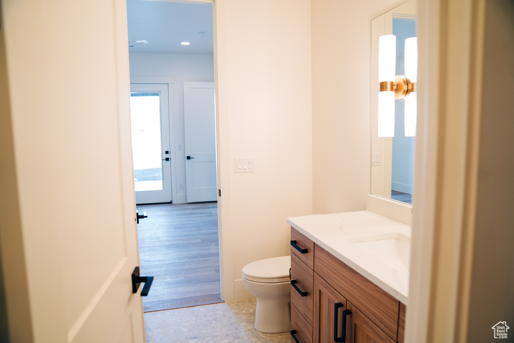 Half bath with vanity, toilet, and recessed lighting