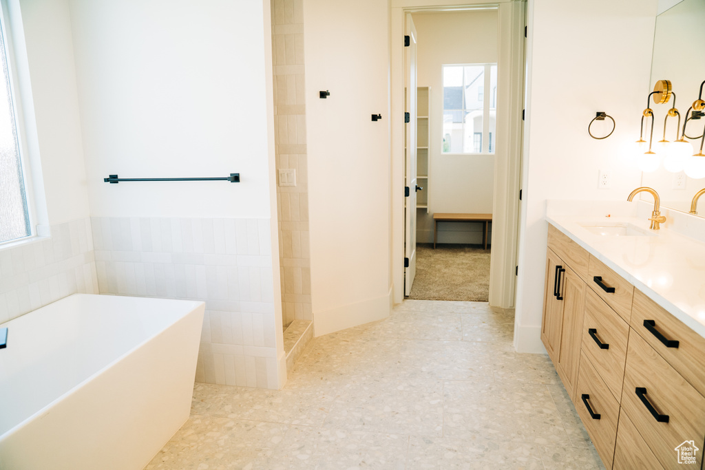 Bathroom with vanity, a soaking tub, and tiled shower