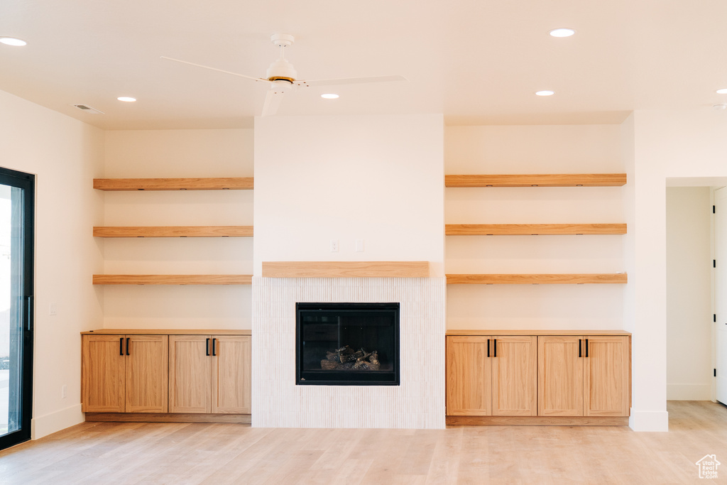 Unfurnished living room with light wood finished floors, recessed lighting, and a fireplace
