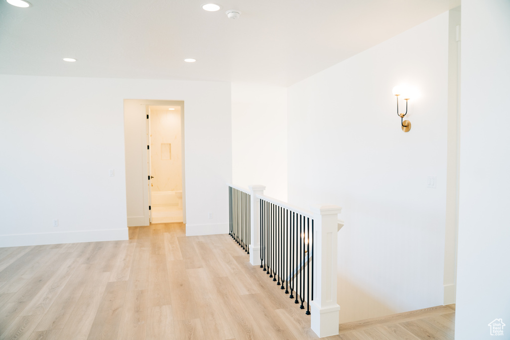 Corridor with light wood-style floors, an upstairs landing, recessed lighting, and baseboards