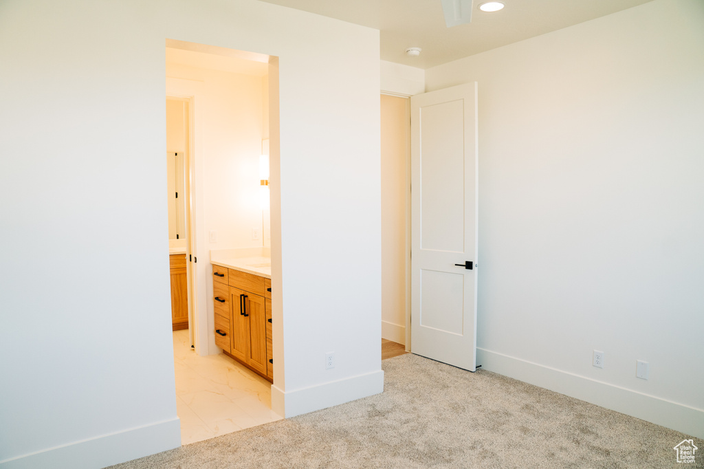 Unfurnished bedroom featuring light carpet, baseboards, connected bathroom, and recessed lighting