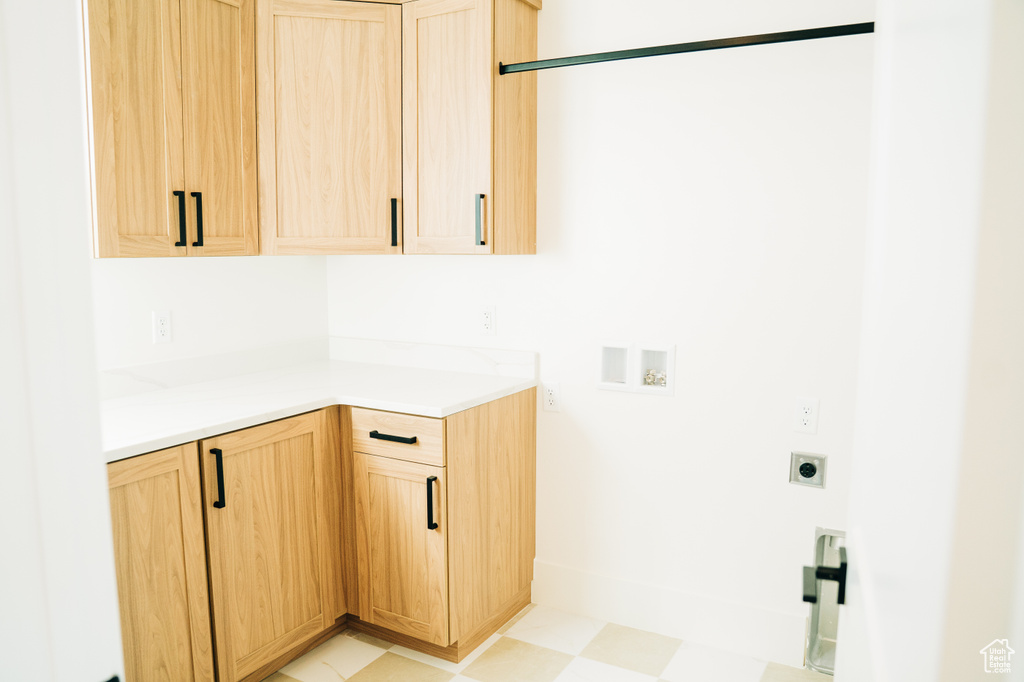 Laundry room featuring electric dryer hookup, cabinet space, hookup for a washing machine, and light flooring