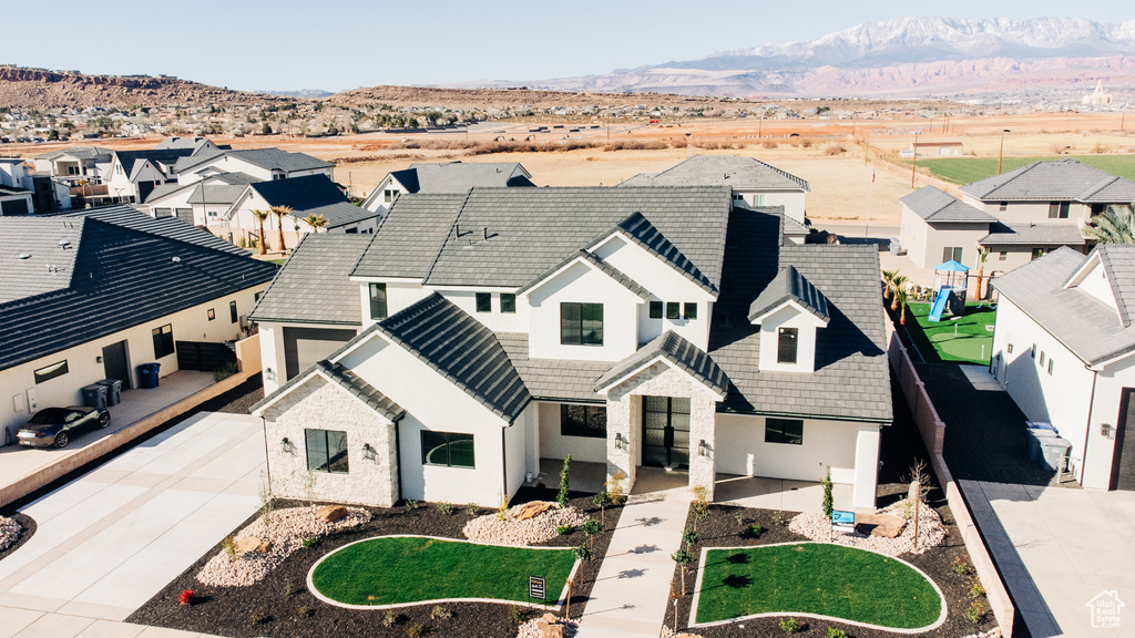 View of front of property with a residential view, a mountain view, and driveway