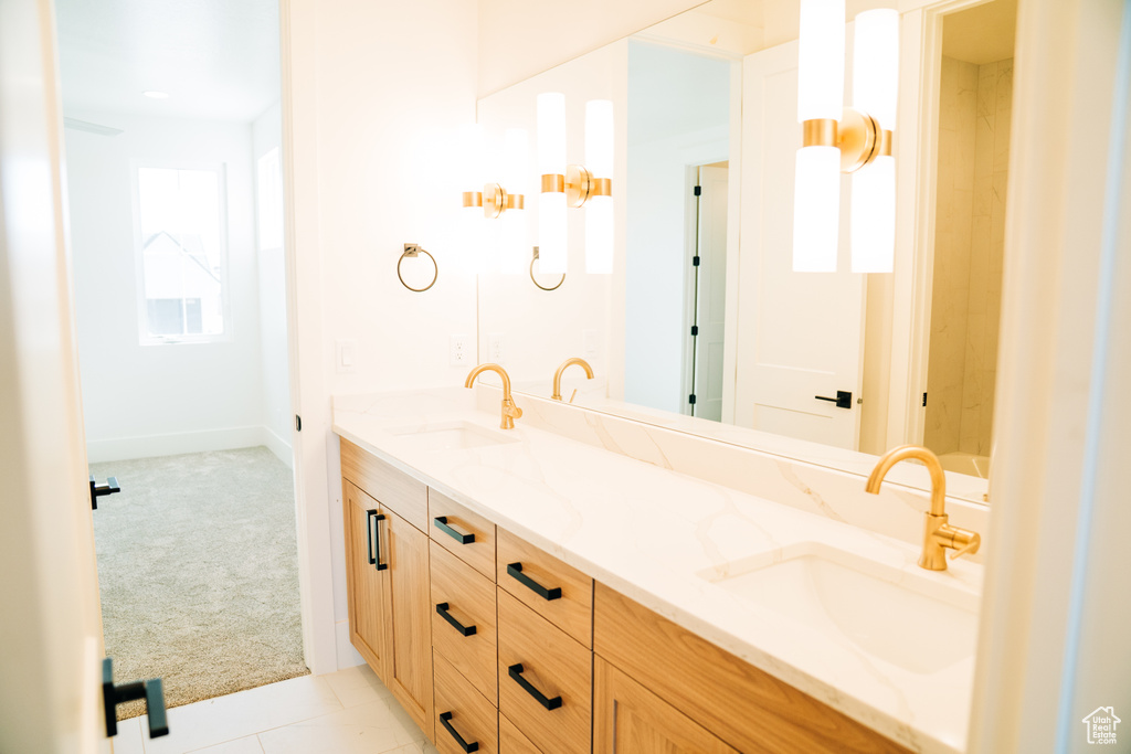 Bathroom featuring double vanity and baseboards