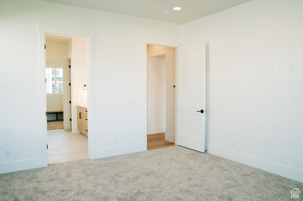 Unfurnished bedroom with light carpet, baseboards, and recessed lighting