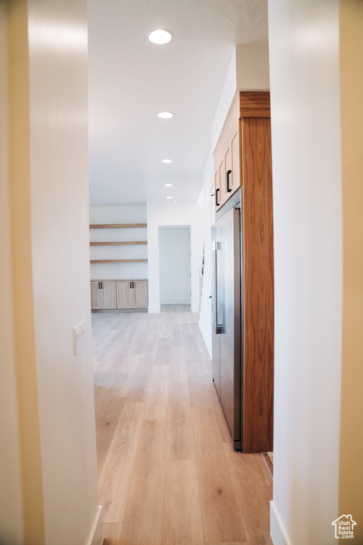 Hall featuring light wood finished floors and recessed lighting