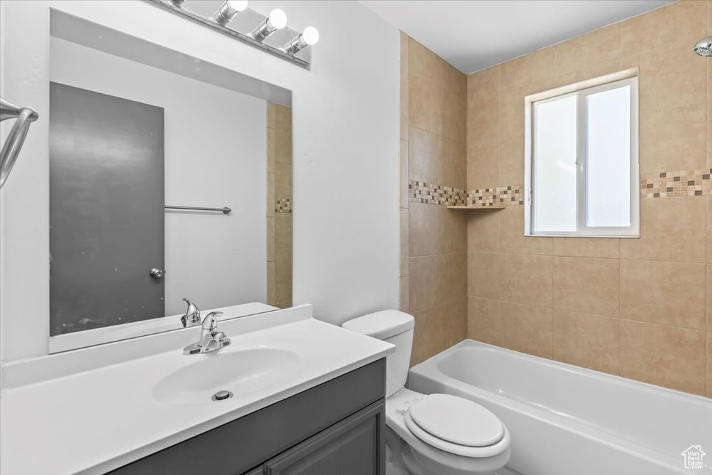 Full bath with toilet, vanity, and shower / washtub combination