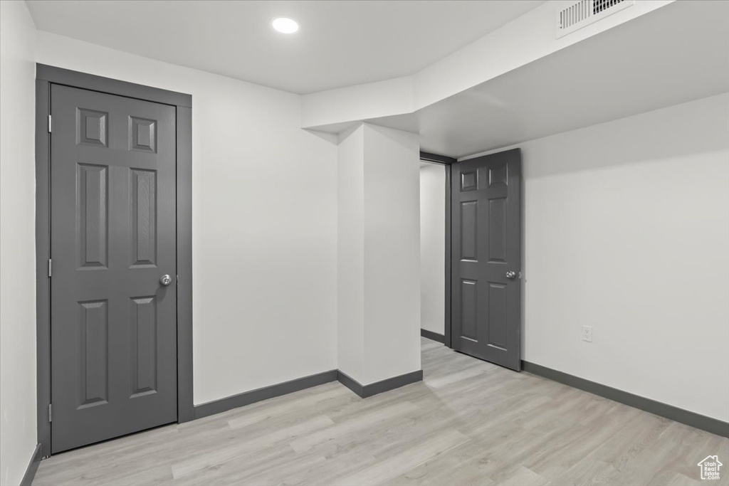 Empty room featuring light wood-style floors, baseboards, and recessed lighting