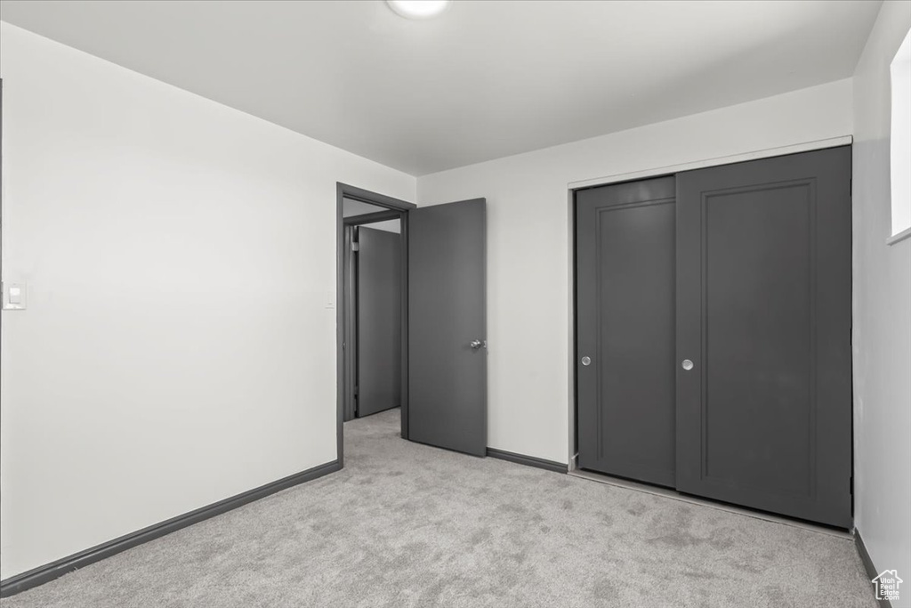 Unfurnished bedroom featuring carpet flooring, a closet, and baseboards