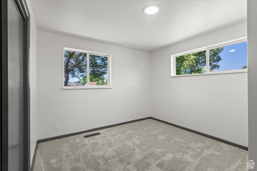 Carpeted empty room featuring baseboards