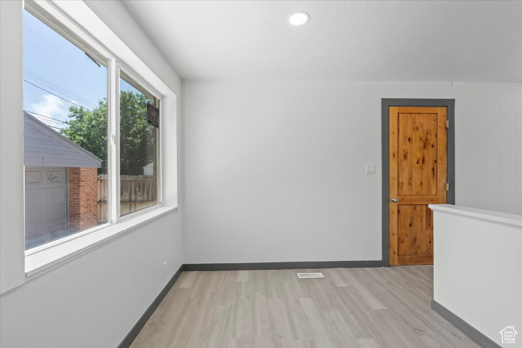 Unfurnished room with light wood finished floors, baseboards, and recessed lighting