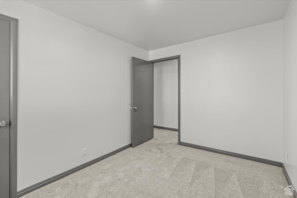 Spare room featuring light carpet and baseboards