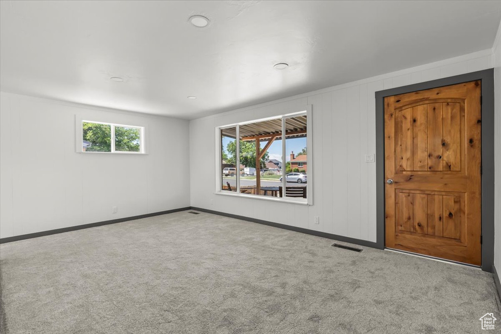 Carpeted spare room featuring baseboards