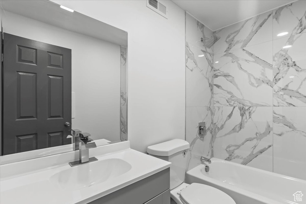 Full bath with vanity, shower / bath combination, and toilet
