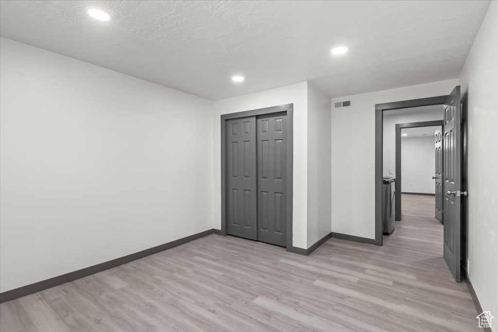 Unfurnished bedroom with light wood finished floors, baseboards, recessed lighting, and a closet