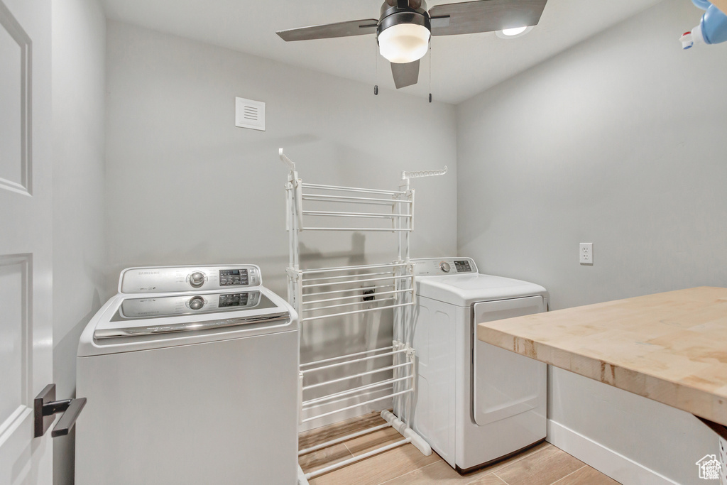Laundry area with washer and dryer, a ceiling fan, and light wood-type flooring
