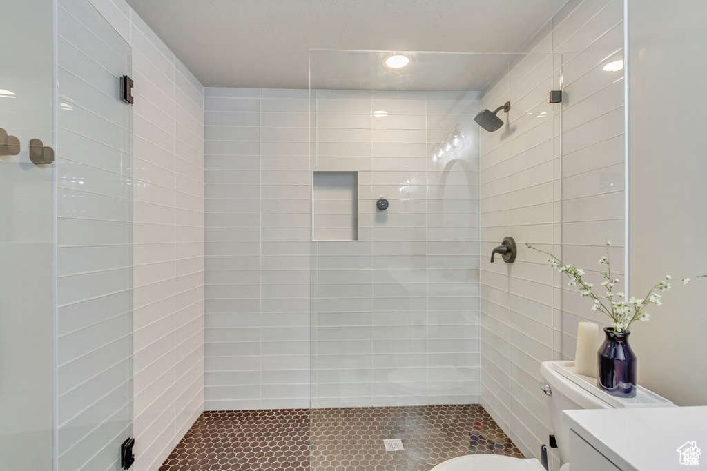 Full bath featuring a stall shower, vanity, toilet, and tile patterned flooring