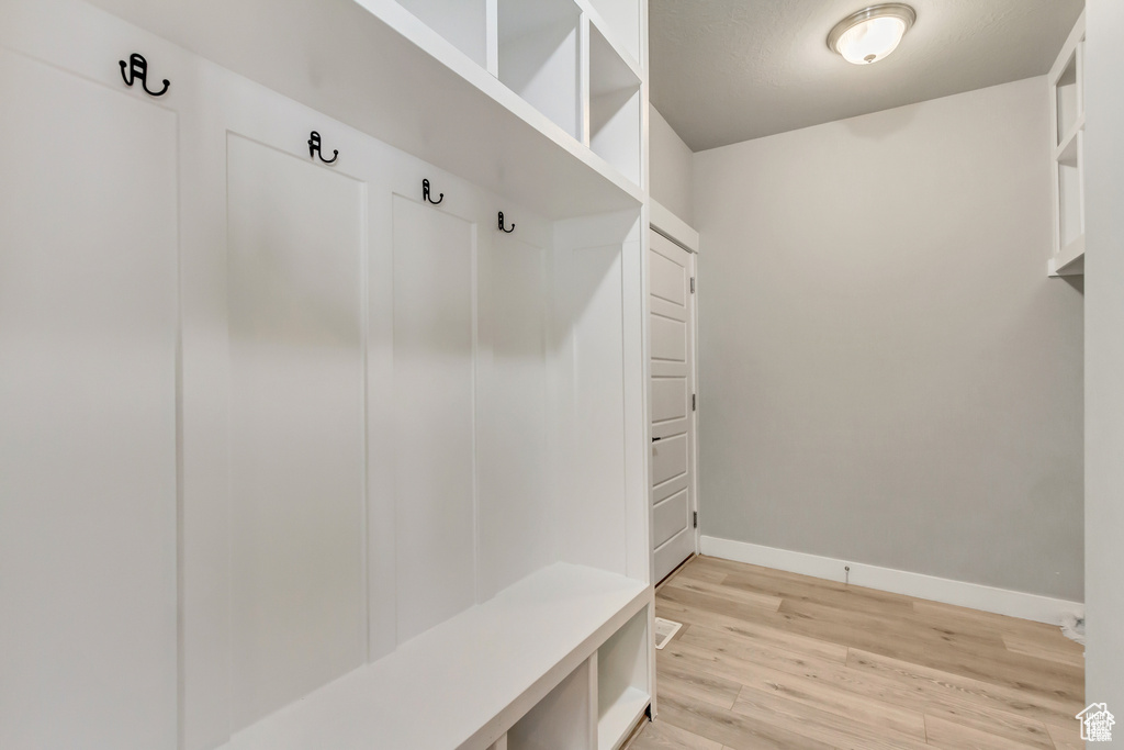 Mudroom with light wood-type flooring and baseboards