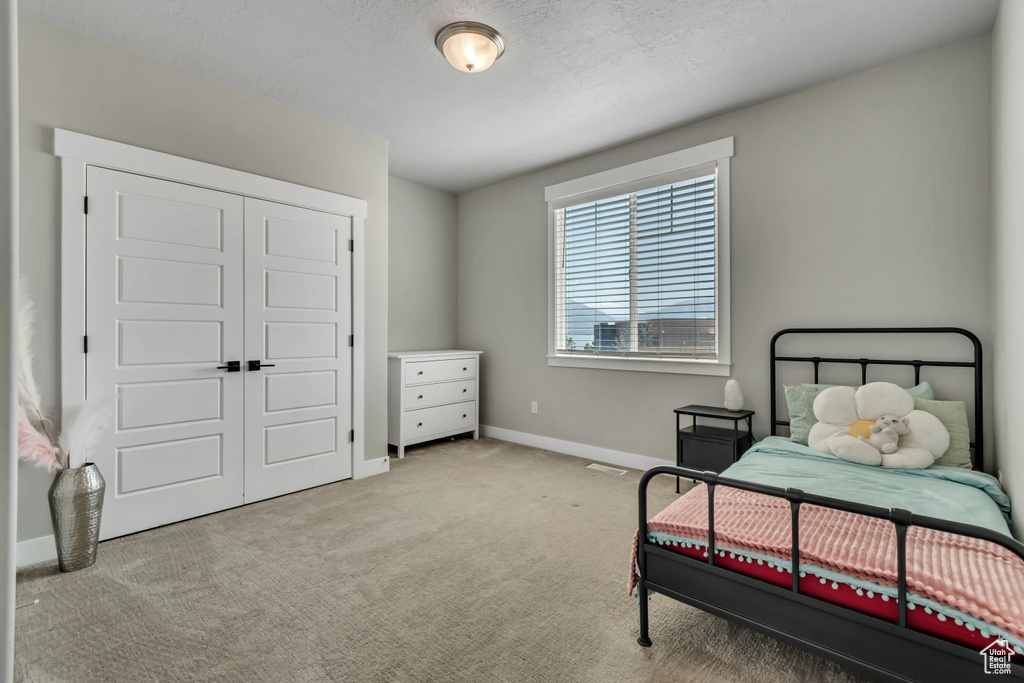 Bedroom featuring carpet, baseboards, and a closet