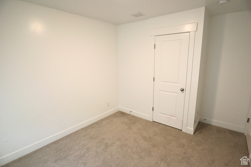 Empty room with light carpet and baseboards