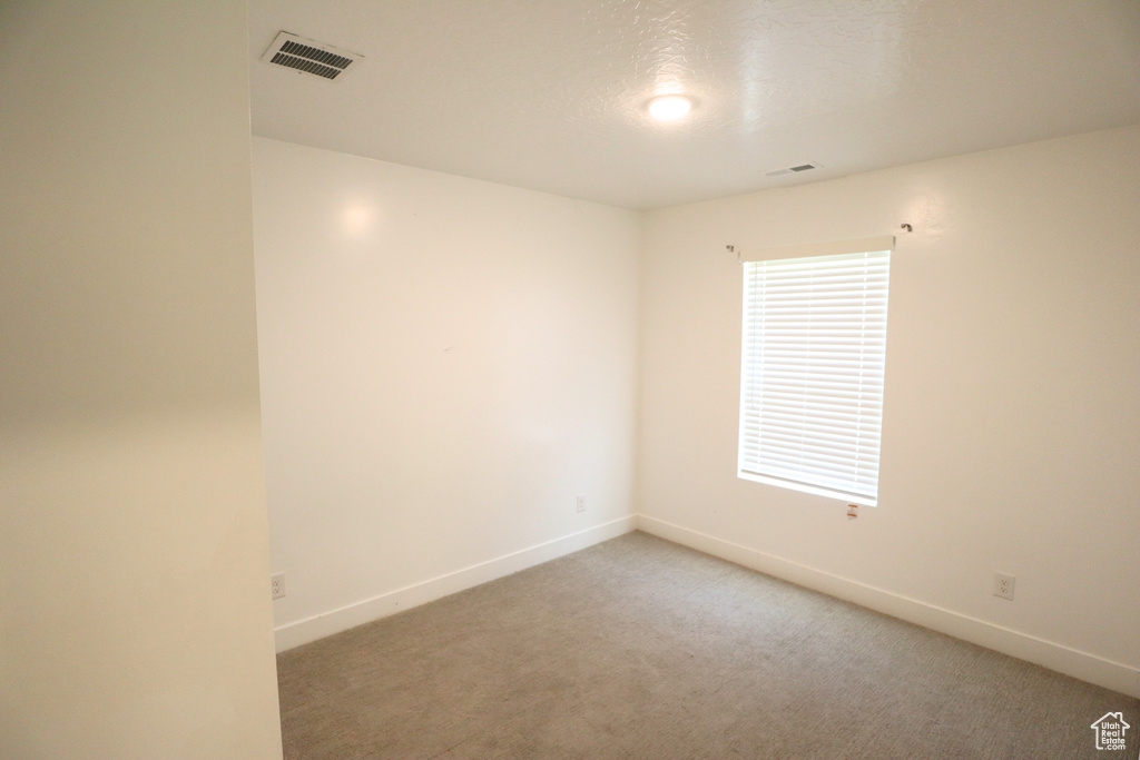 Carpeted spare room with baseboards