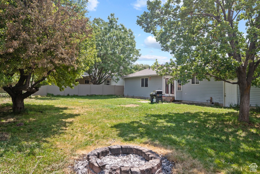 View of yard with a fire pit and entry steps