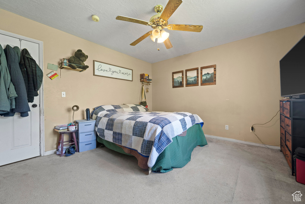 Bedroom featuring carpet floors, baseboards, and a ceiling fan