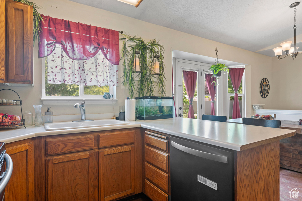 Kitchen featuring stainless steel dishwasher, a sink, and light countertops