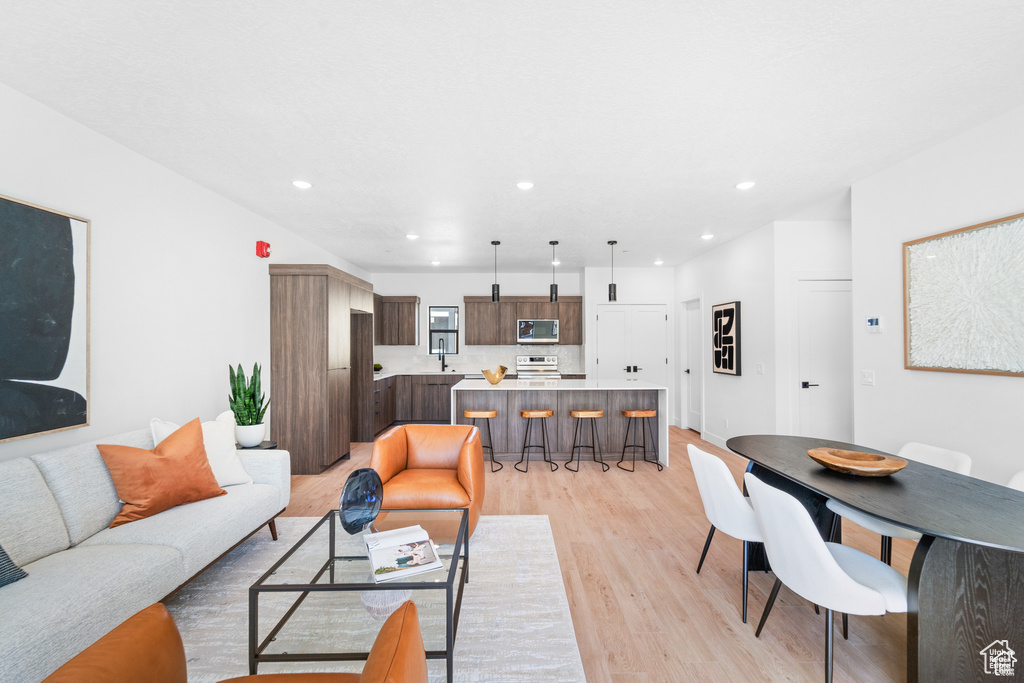 Living area with light wood-type flooring and recessed lighting