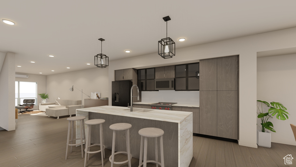 Kitchen with a sink, modern cabinets, light countertops, a kitchen bar, and light wood-style flooring