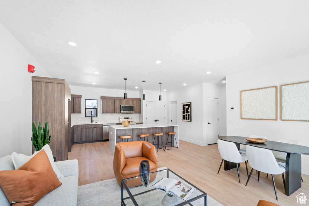 Living area with light wood-type flooring, recessed lighting, and baseboards