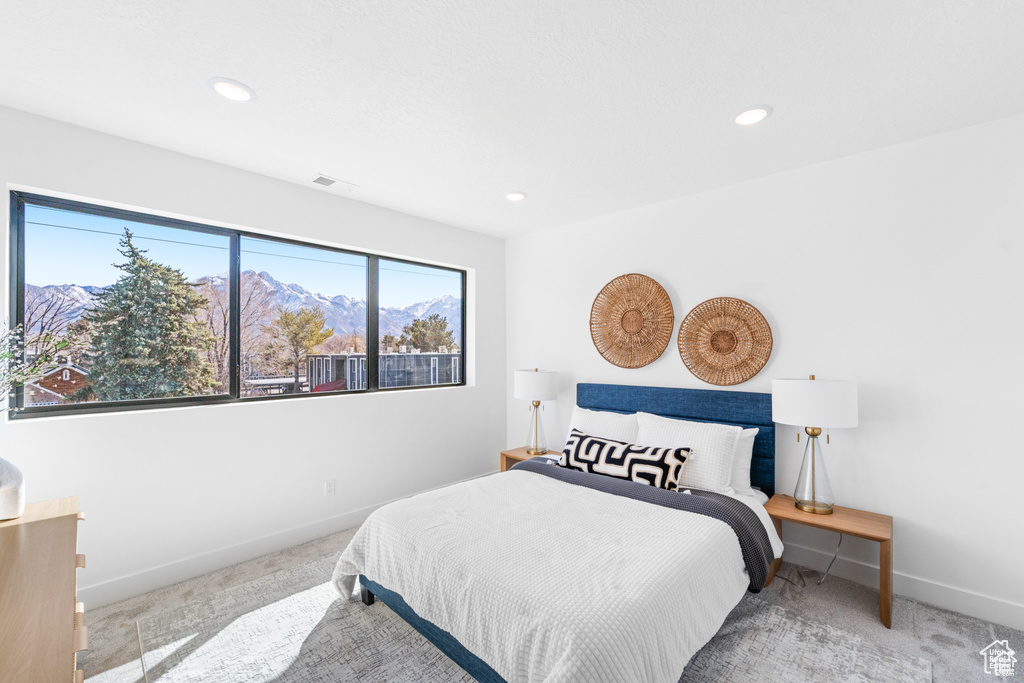 Carpeted bedroom featuring baseboards, recessed lighting, and a mountain view