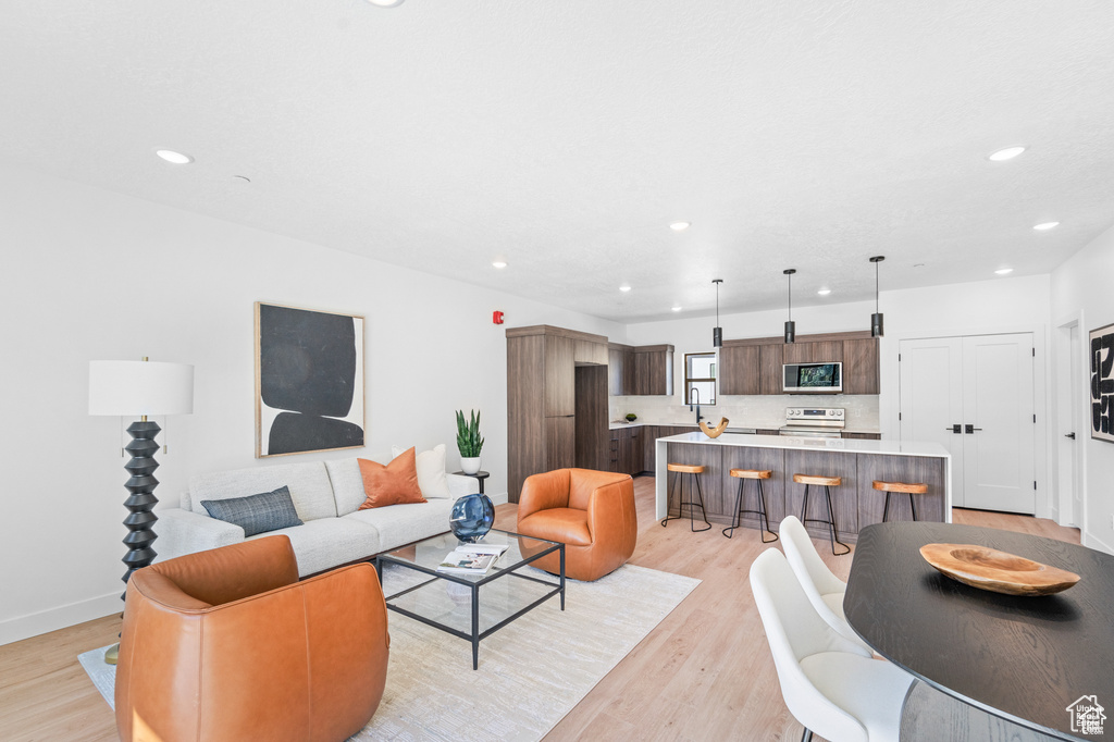 Living room featuring recessed lighting, light wood-style floors, and baseboards