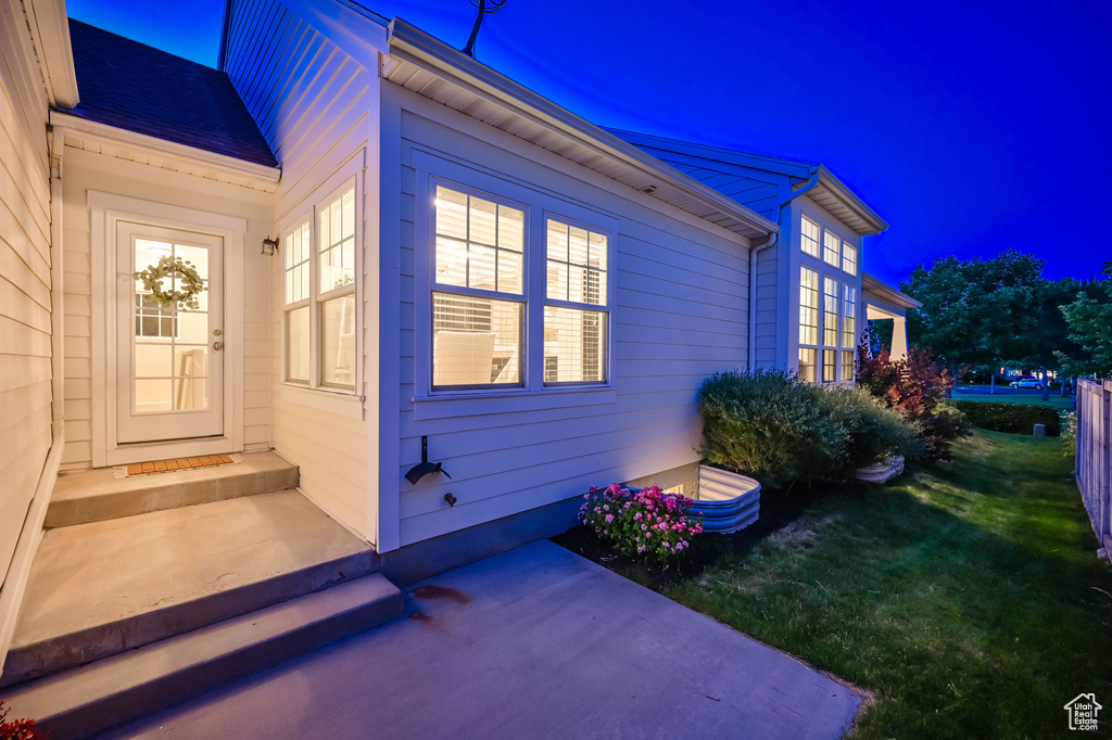 Property exterior at twilight featuring a patio and a yard