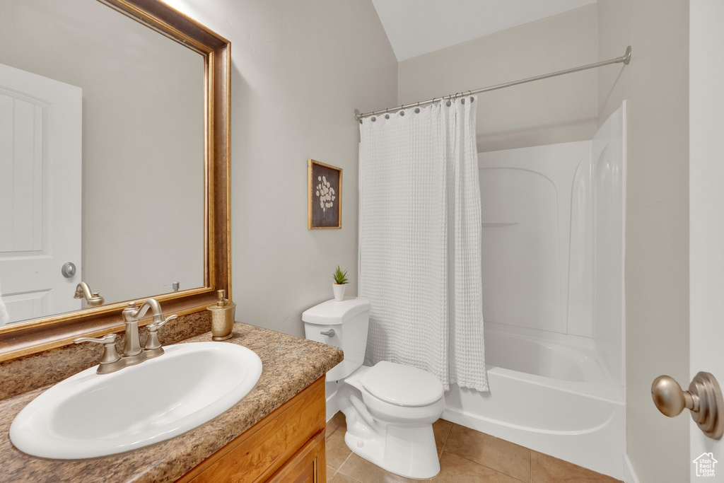 Full bath featuring vanity, toilet, tile patterned floors, and shower / bath combo
