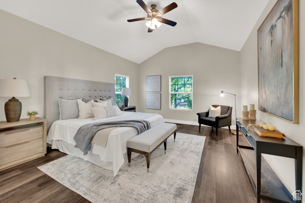 Bedroom with vaulted ceiling, dark wood-type flooring, and a ceiling fan