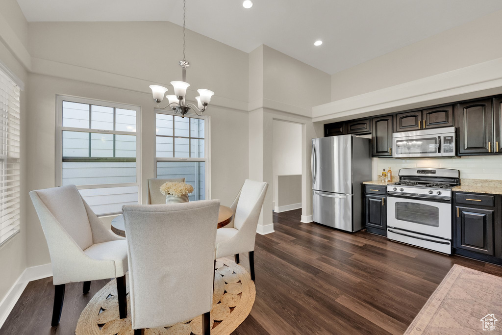 Dining room featuring a chandelier, dark wood-type flooring, baseboards, recessed lighting, and high vaulted ceiling