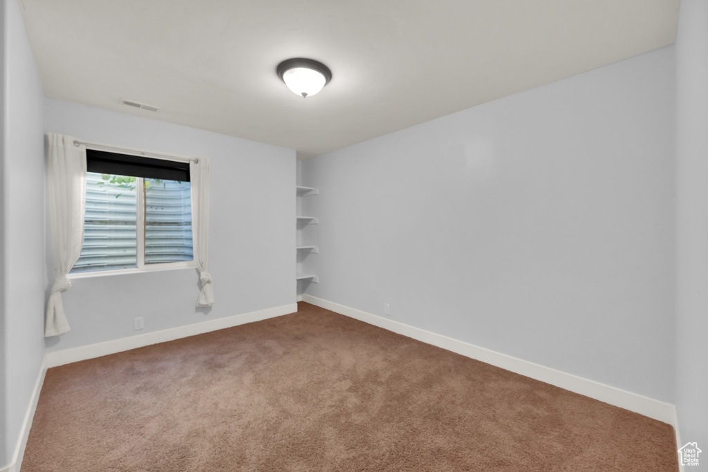 Empty room featuring carpet floors and baseboards